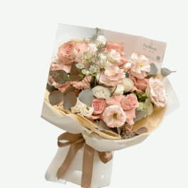 Bouquet of blush and white roses wrapped in cream paper