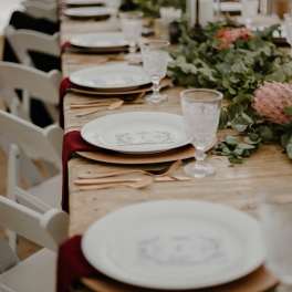 Wedding table setting with pink floral centerpieces and greenery