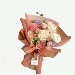 Bouquet of pink and white roses wrapped in peach paper