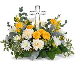 Low yellow and white flower arrangement with a central clear crystal cross.