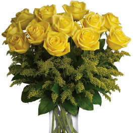Arrangement of yellow roses in a clear glass vase with yellow filler accents