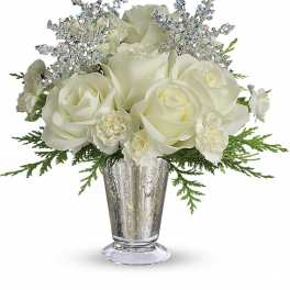 White roses and small white blooms with silver snowflake picks in a silver glass vase