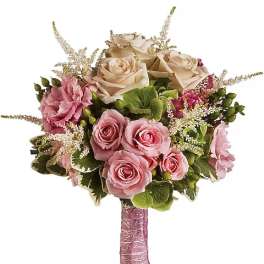 Hand-tied bouquet of blush pink and cream roses with pink accents and wrapped stems