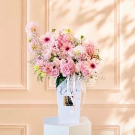 Pink mixed flower arrangement in a white gift box with ribbon