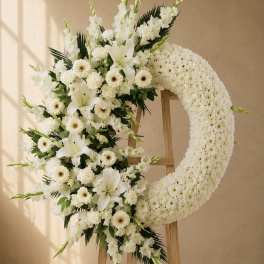 White floral funeral wreath on a wooden stand