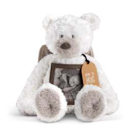 White teddy bear holding a framed photo and orange tag