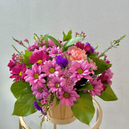 Pink daisy bouquet in a small wooden container