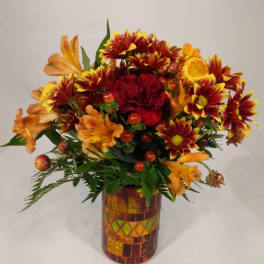 Autumn bouquet of orange and red flowers in a mosaic vase