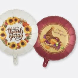 Three Thanksgiving-themed foil balloons with fall designs and text