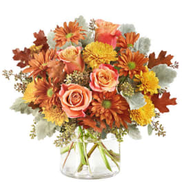 Bouquet of orange and yellow flowers in a clear glass vase