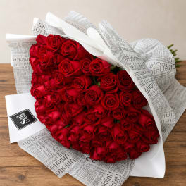 Bouquet of red roses wrapped in white printed paper