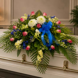 Floral casket spray with pink roses, white mums, and blue ribbon