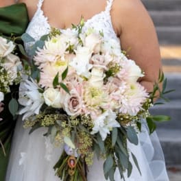 Bride holding a white and blush bouquet with roses and daisies