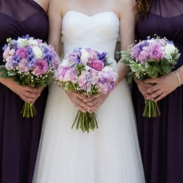 Bride and bridesmaids holding lavender and pink bouquets