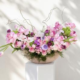 Large pink and purple floral arrangement in a shallow bowl