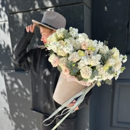 Large bouquet of white and blush flowers in a beige hatbox