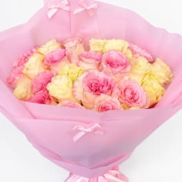 Pink and pale yellow roses wrapped in pink paper with ribbon bows