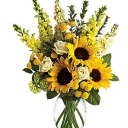 Sunflower bouquet with white roses in a clear glass vase