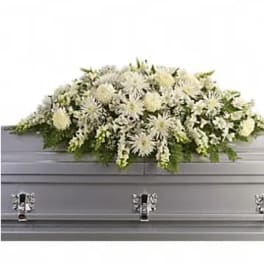 White floral casket spray on a gray casket