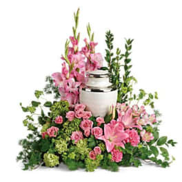 Pink flowers arranged around a white urn-shaped vase