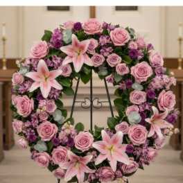 Pink and purple floral wreath on a black stand
