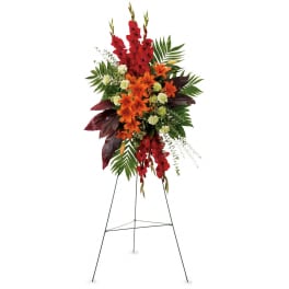 Tall red and orange floral standing spray on a metal easel
