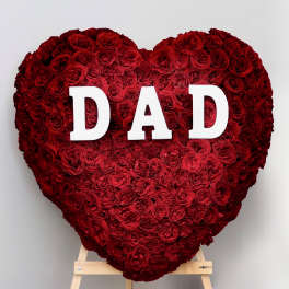 Heart-shaped red rose arrangement with white letters spelling DAD