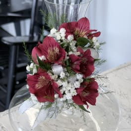 Pink alstroemeria arrangement in a clear glass vase with white filler flowers