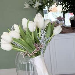 White tulip bouquet with small pink filler flowers and a matching boutonniere