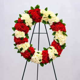 Red and white floral wreath on a black easel