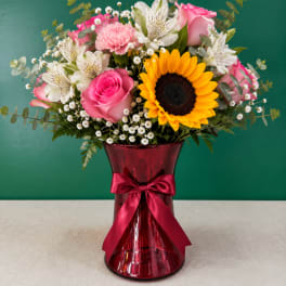 Pink and white mixed bouquet in a red glass vase with a ribbon