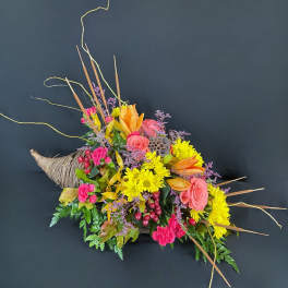 Colorful floral arrangement in a woven horn-shaped container