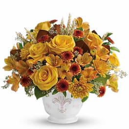 Yellow roses and autumn flowers arranged in a white vase