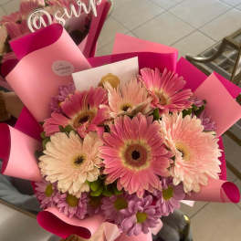 Pink and cream gerbera daisy bouquet wrapped in pink paper