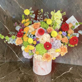 Colorful mixed bouquet in a pink marble-look cylinder vase