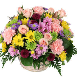 Mixed bouquet of pink, yellow, and purple flowers in a basket