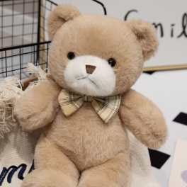 Plush teddy bear with a plaid bow tie