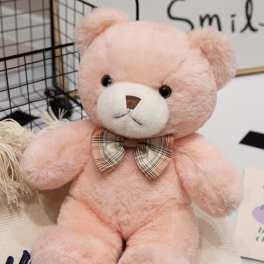 Pink plush teddy bear with a plaid bow tie