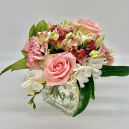 Pink rose and mixed flower bouquet in a clear glass vase