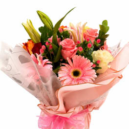 Pink and peach mixed bouquet with roses, lilies, and a gerbera daisy in pink wrap