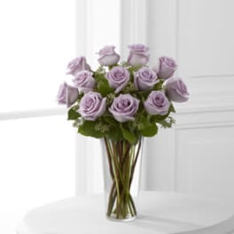 Lavender roses arranged in a clear glass vase