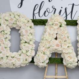 Floral letters spelling DAD made of pale roses and buds