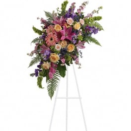 Standing floral spray with pink, purple, and peach flowers on an easel