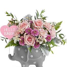 Pink rose bouquet in a gray elephant planter with a Hello Baby sign