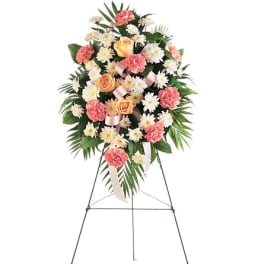 Standing floral spray with pink carnations, peach roses, and white daisies