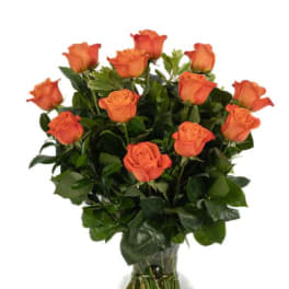 Orange roses arranged in a clear glass vase