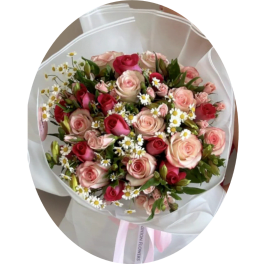 Bouquet of pink and red roses with small white daisies wrapped in white paper