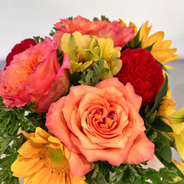 Bouquet of peach roses, yellow sunflowers, and red carnations
