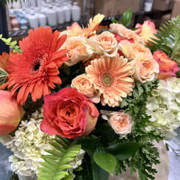 Large bouquet of peach and coral roses with orange gerbera daisies