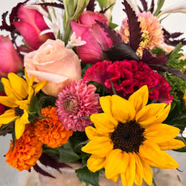 Mixed bouquet with sunflowers, roses, and orange and pink blooms